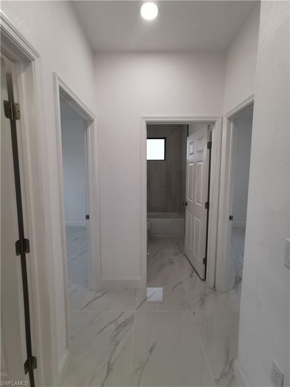Hallway with light marble finish flooring and recessed lighting