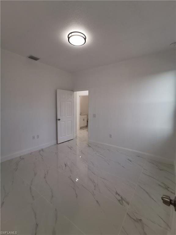 Spare room with light marble finish floors and baseboards