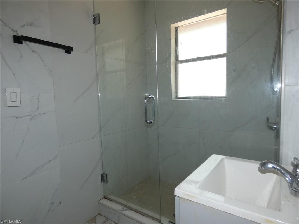 Full bathroom with a sink and a shower stall
