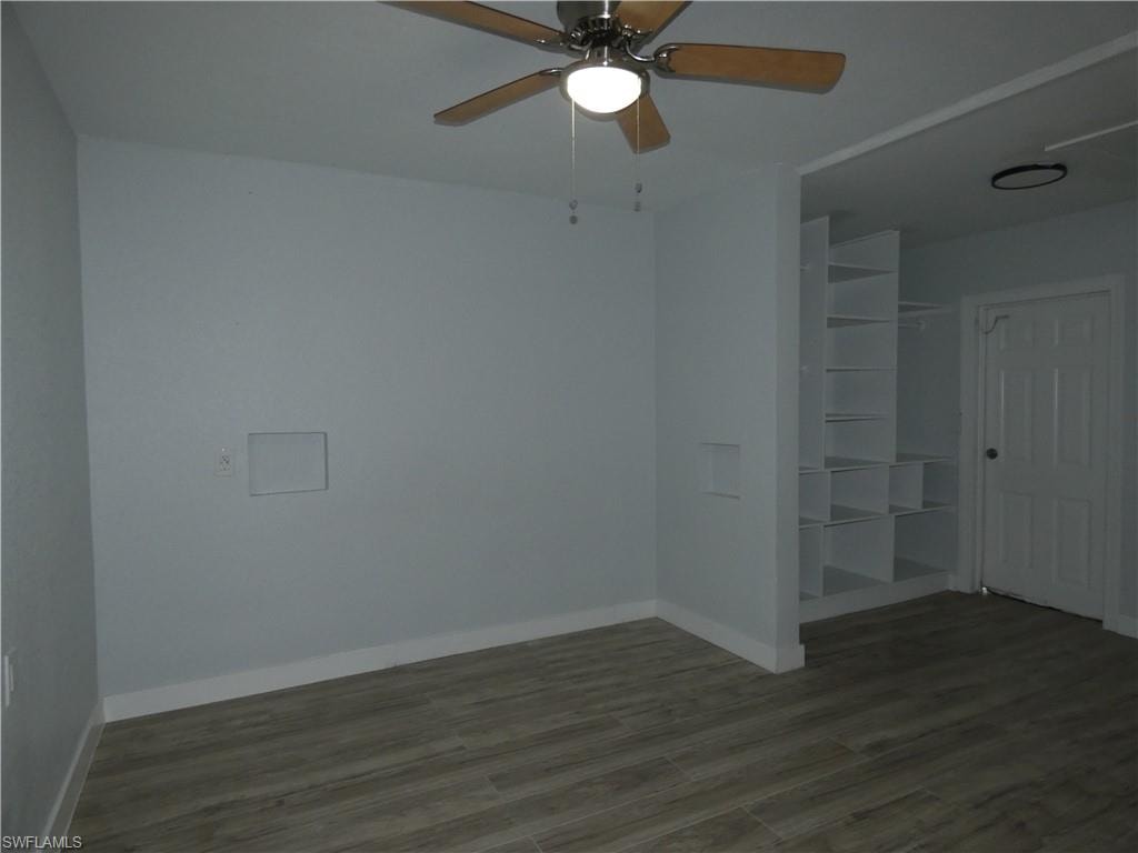 Unfurnished bedroom featuring wood finished floors, baseboards, and a closet