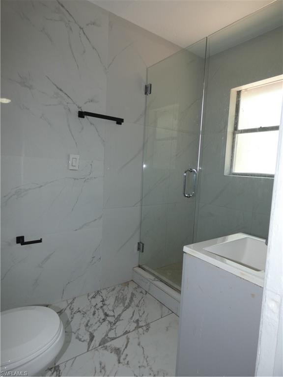 Full bathroom featuring marble look tiles, toilet, a marble finish shower, and a sink