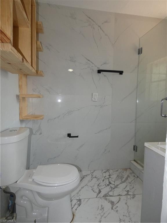 Full bath featuring marble look tile flooring, toilet, and a marble finish shower