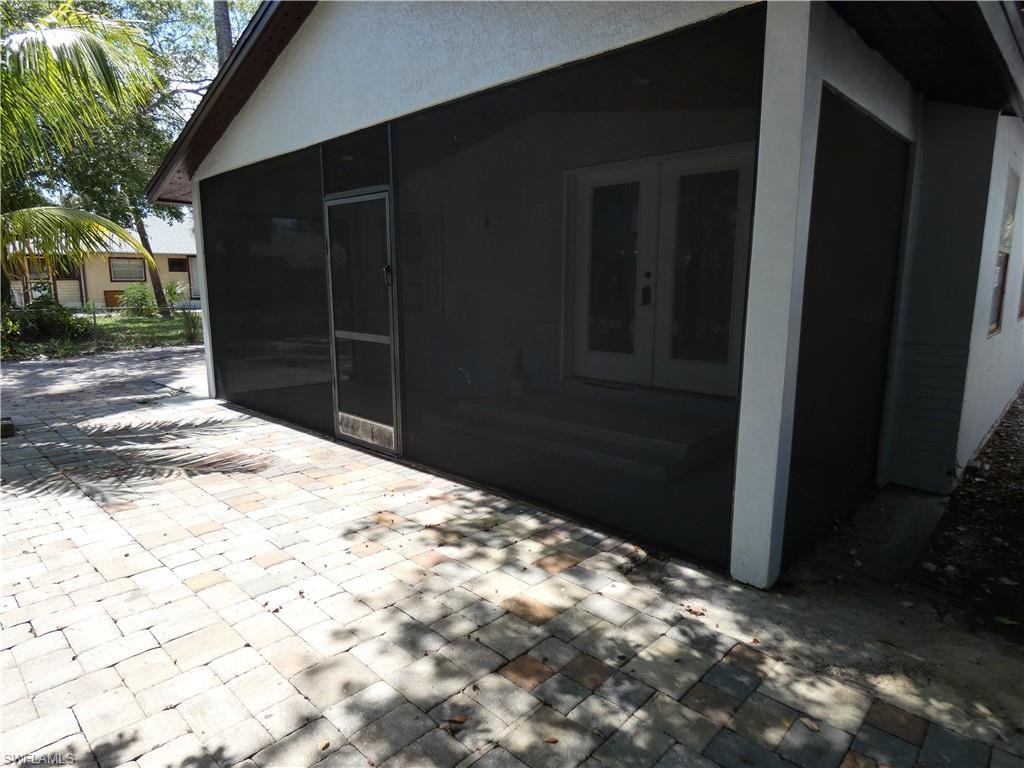 View of home's exterior with french doors, a patio, a sunroom, and stucco siding