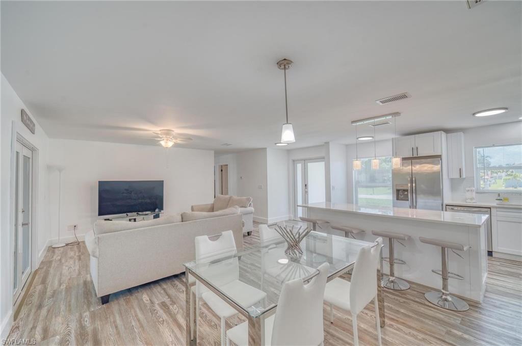 Dining room with light wood-type flooring, a ceiling fan, and baseboards