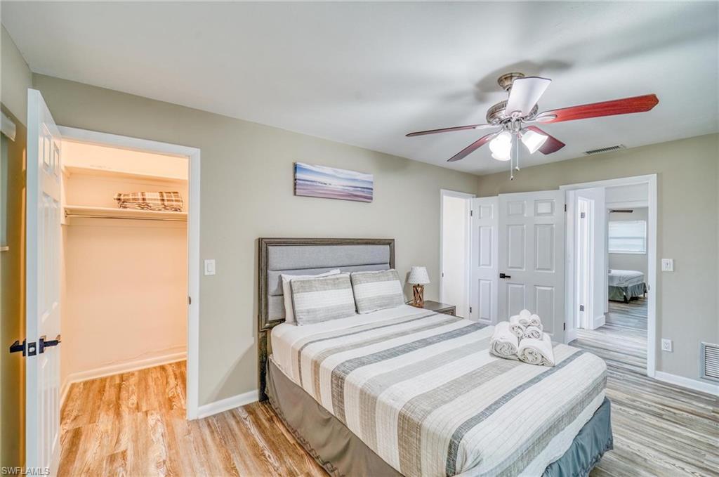 Bedroom with light wood finished floors, a closet, a spacious closet, and baseboards
