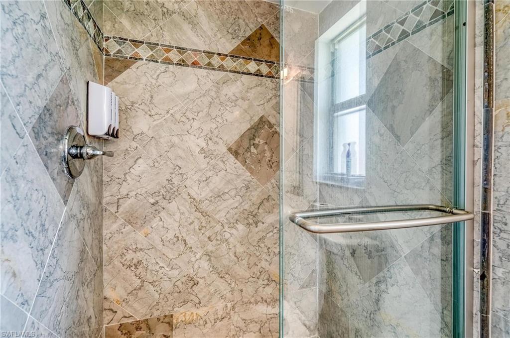 Bathroom featuring a shower stall and healthy amount of natural light