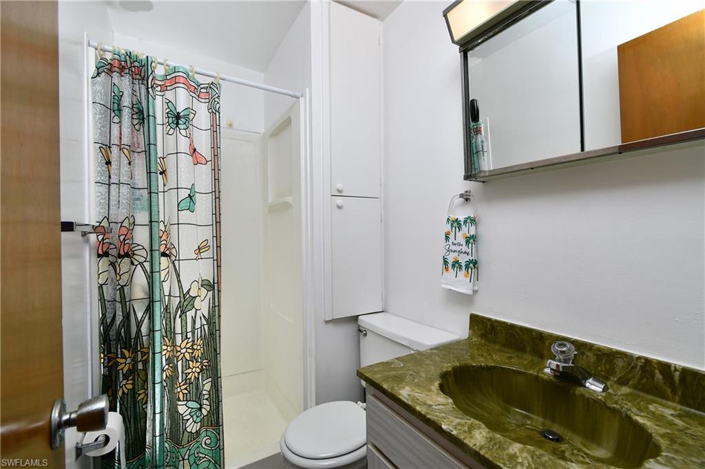Full bathroom with a shower stall, toilet, and vanity