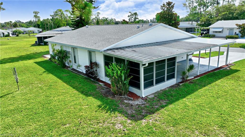 Rear view of property with a yard, a sunroom, and a residential view