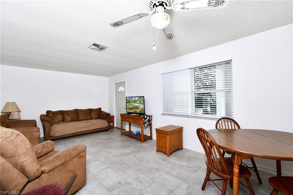 Living room with ceiling fan and a textured ceiling