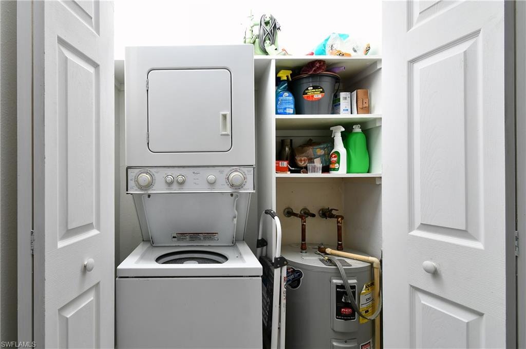 Laundry room with stacked washing machine and dryer and electric water heater