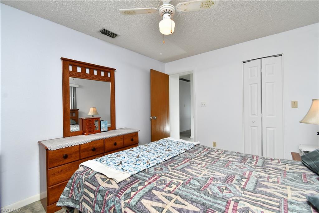 Bedroom featuring a textured ceiling, a closet, and a ceiling fan