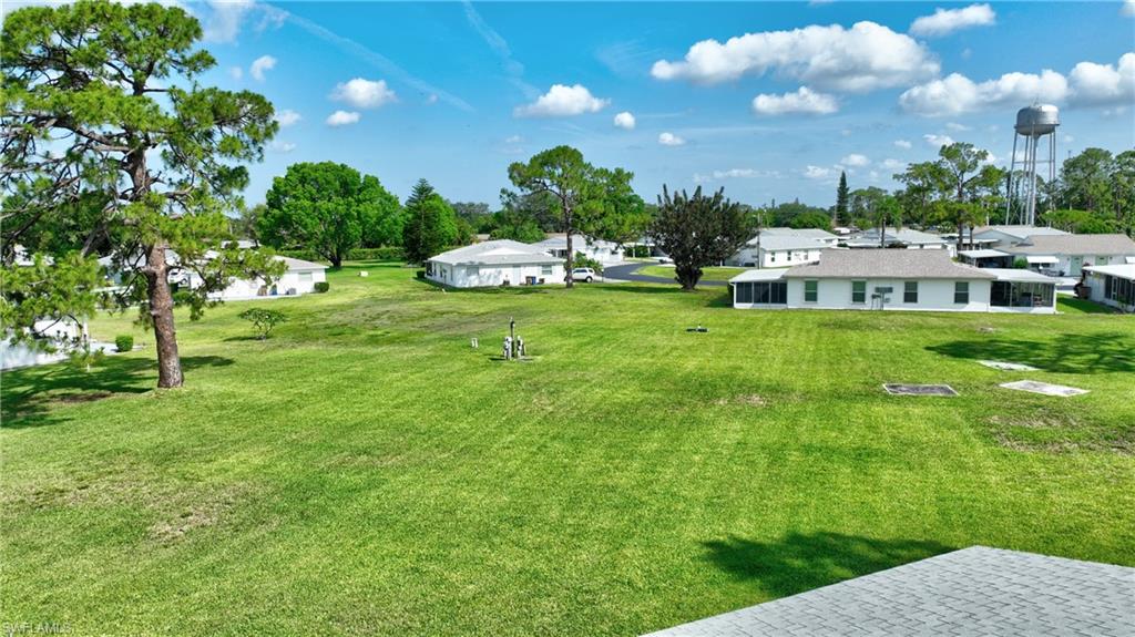 View of green lawn with a residential view