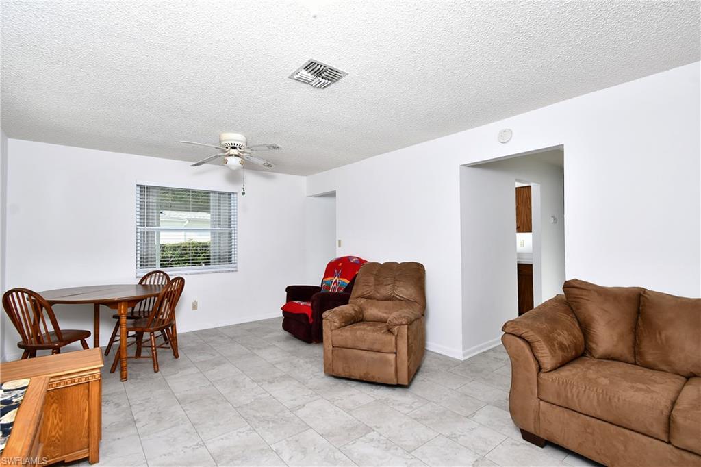 Living area with a ceiling fan and a textured ceiling