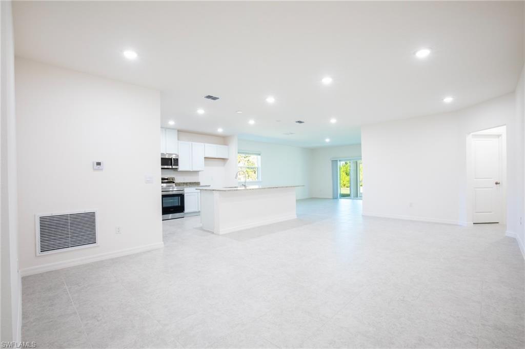 Unfurnished living room with recessed lighting and baseboards