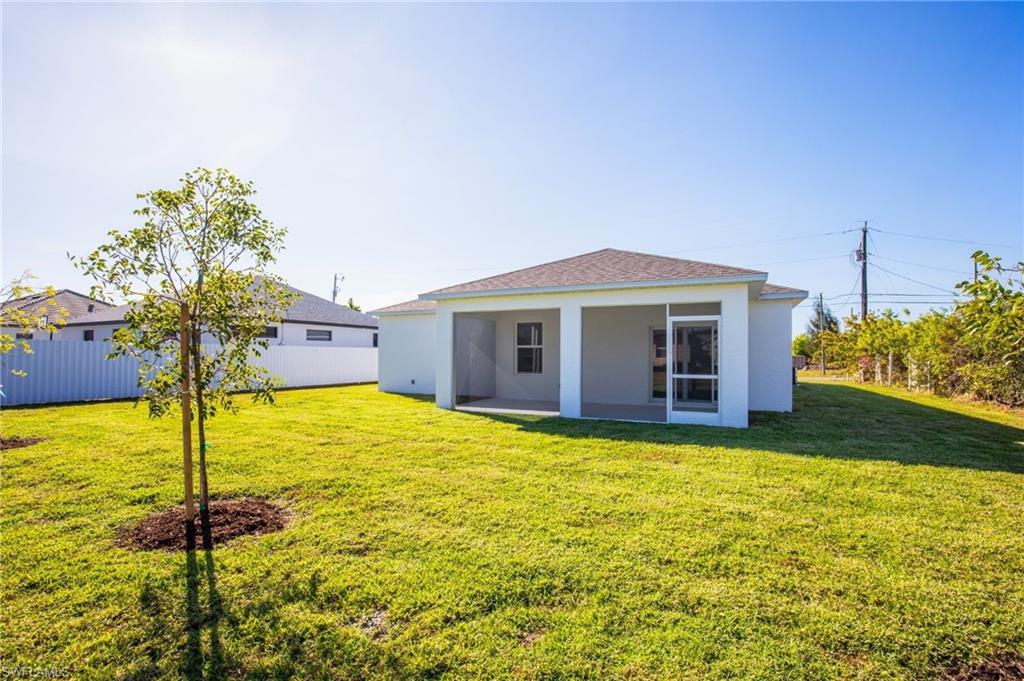 Back of house with a lawn, stucco siding, and a patio
