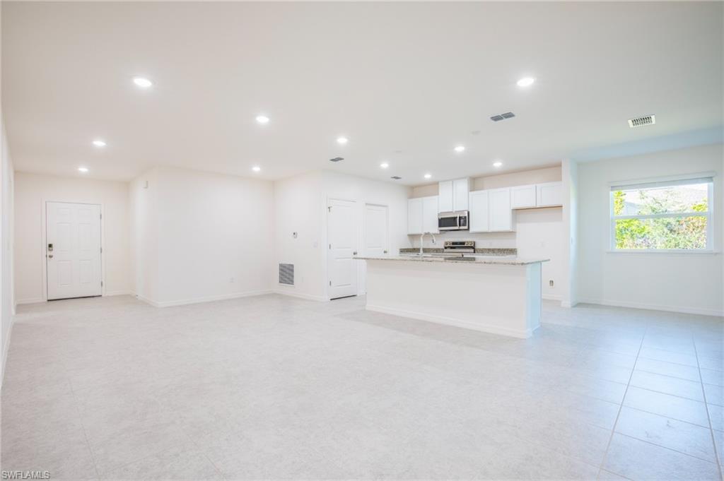 Unfurnished living room with baseboards and recessed lighting