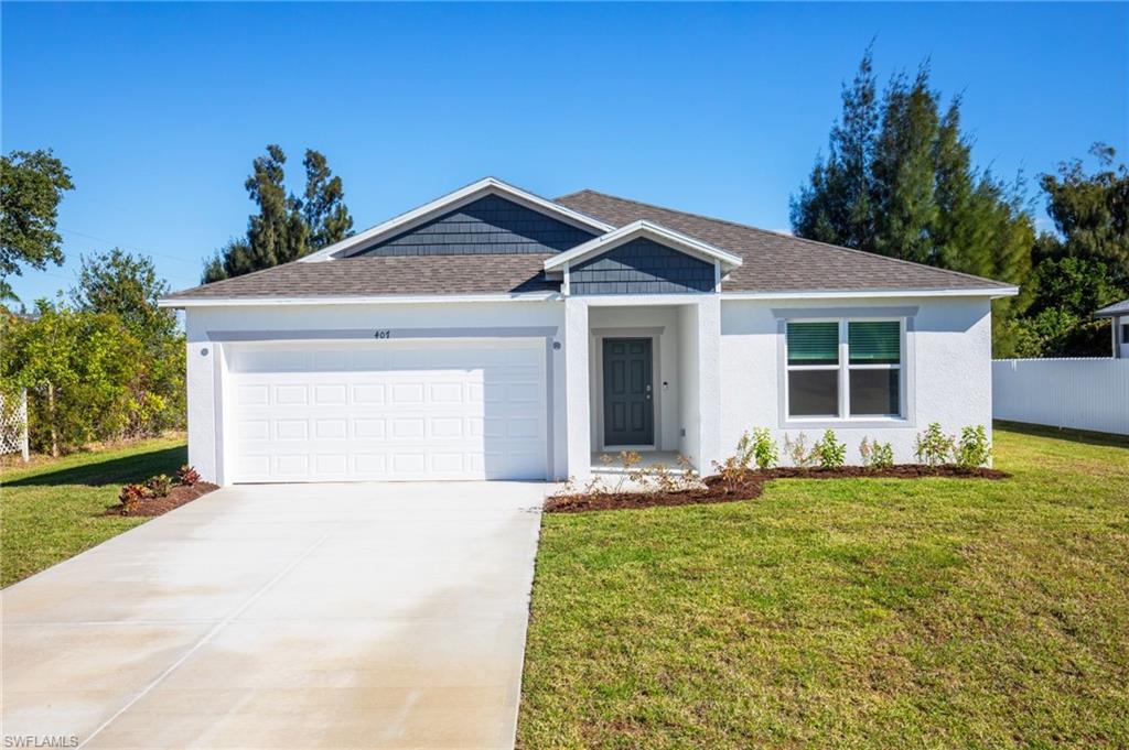 Single story home with a front yard, stucco siding, a garage, and concrete driveway