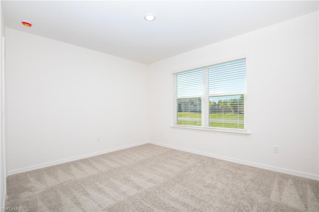 Carpeted spare room featuring baseboards