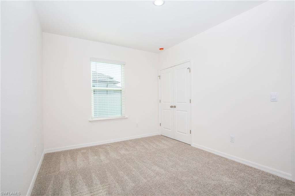 Empty room with baseboards and carpet