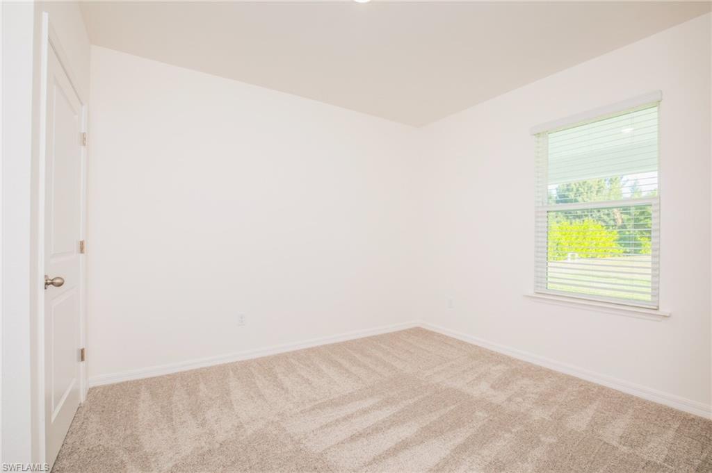 Carpeted empty room featuring baseboards
