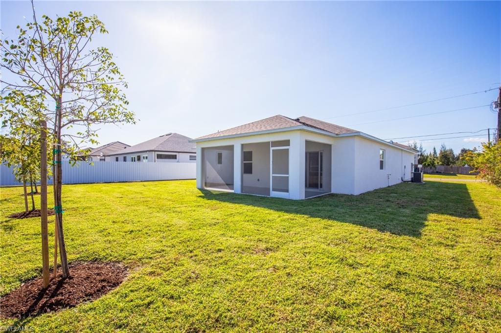 Rear view of property with stucco siding and a sunroom
