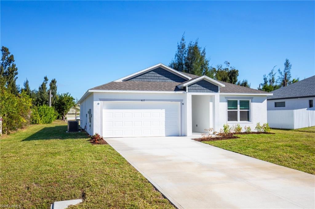 Ranch-style home with roof with shingles, a front yard, a garage, driveway, and stucco siding