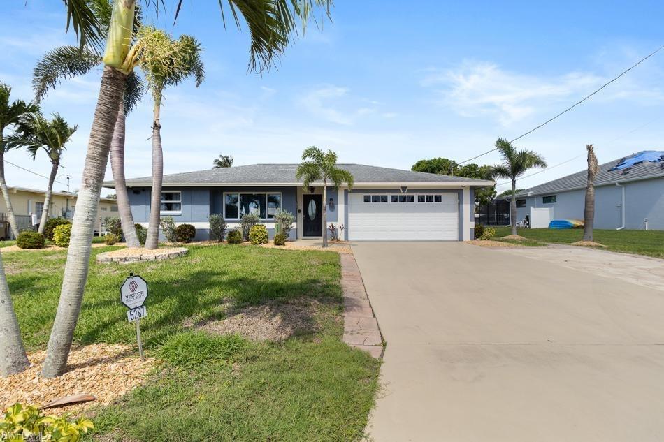 Ranch-style house featuring an attached garage, driveway, and a front lawn