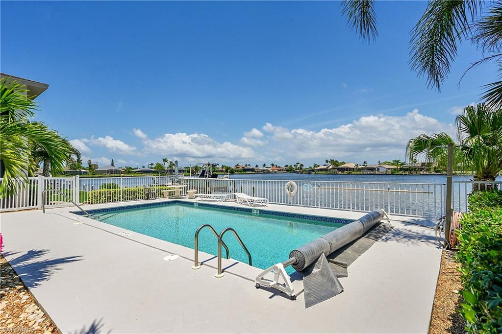 View of swimming pool with a patio and a water view