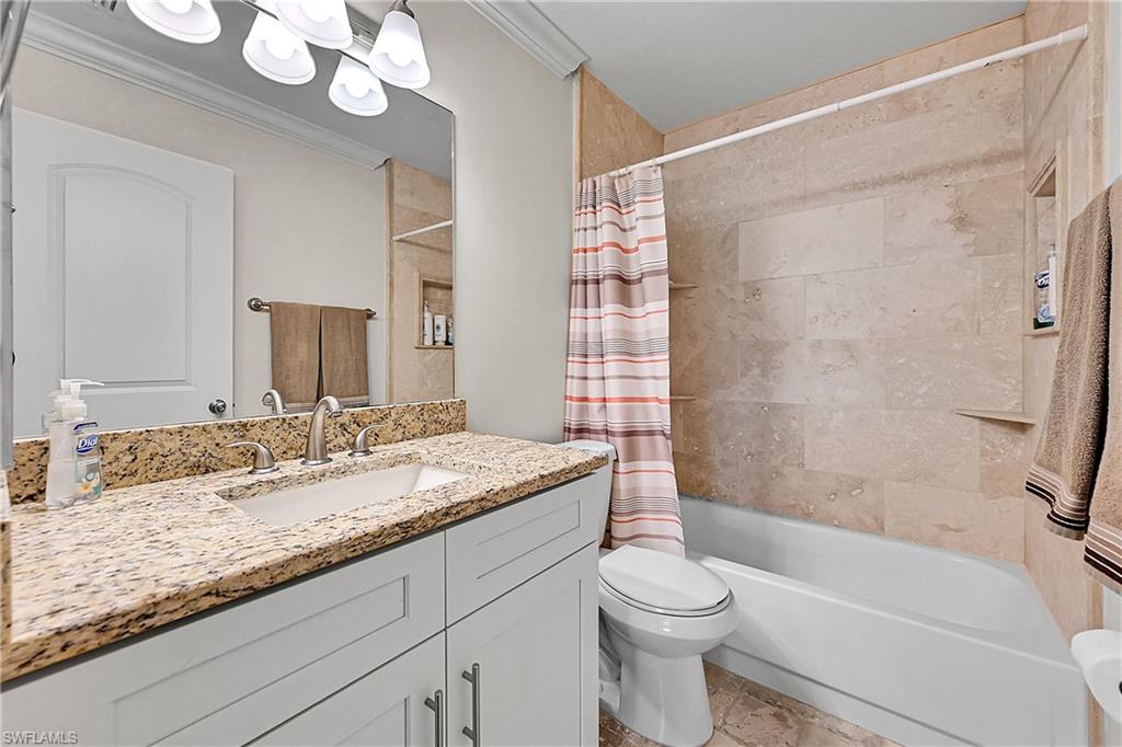 Bathroom with vanity, toilet, shower / bathtub combination with curtain, and crown molding