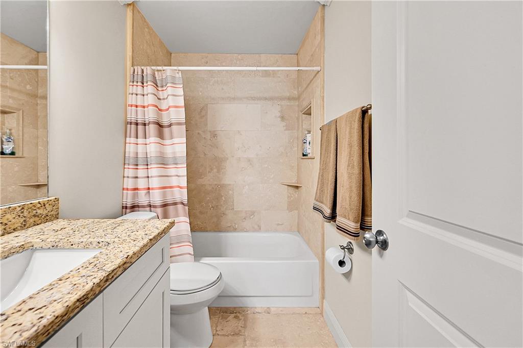 Full bath featuring vanity, toilet, and shower / bath combination with curtain