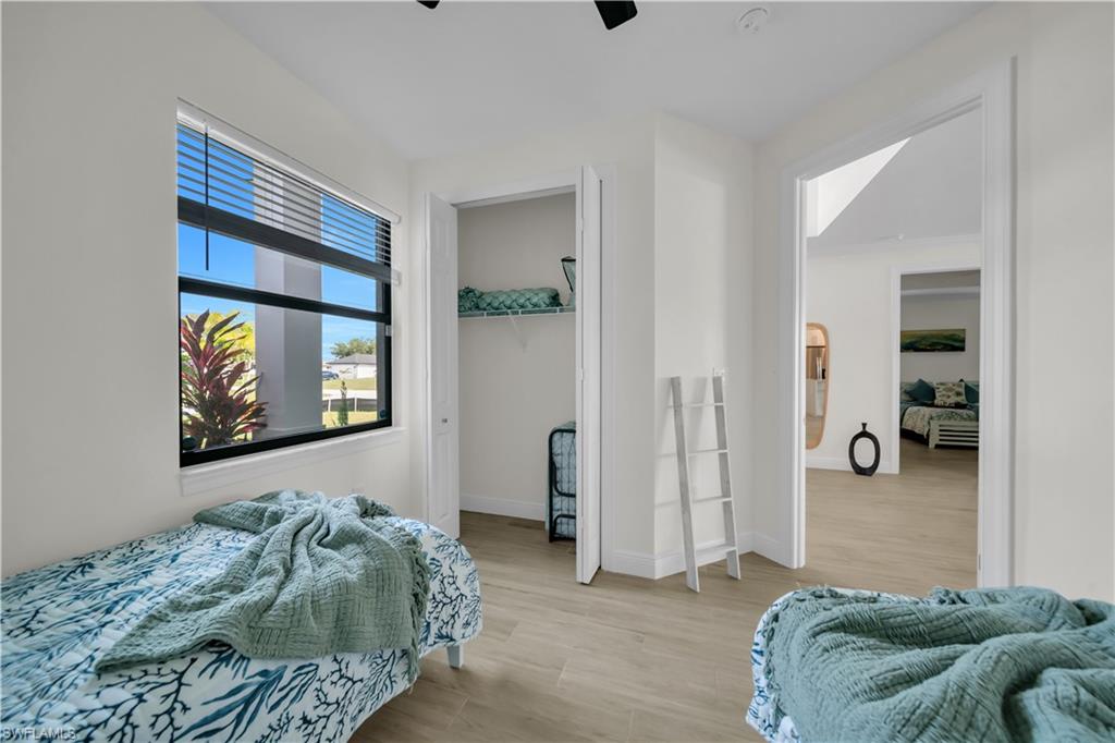 Bedroom with light wood-style flooring, baseboards, and a ceiling fan