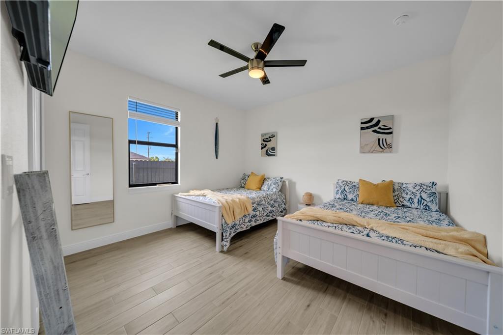 Bedroom with wood finished floors, baseboards, and ceiling fan