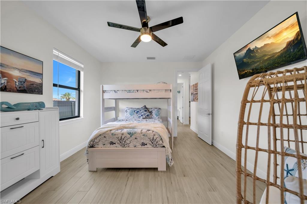 Bedroom with light wood-style flooring, baseboards, and a ceiling fan