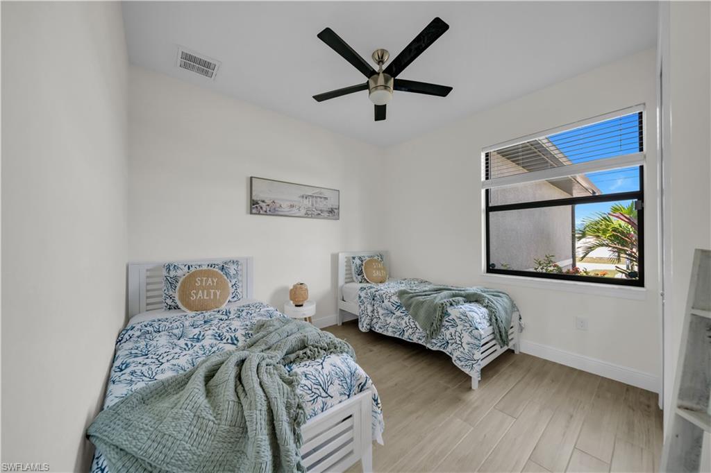 Bedroom featuring baseboards, wood finished floors, and ceiling fan