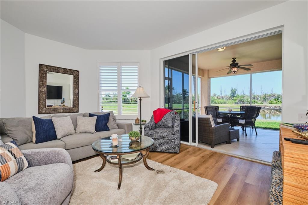 Living area featuring healthy amount of natural light, ceiling fan, wood finished floors, and a water view