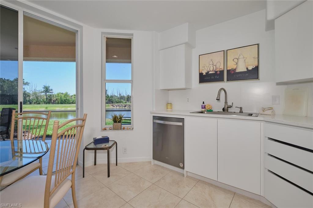 Kitchen featuring a sink, stainless steel dishwasher, white cabinets, light countertops, and light tile patterned flooring