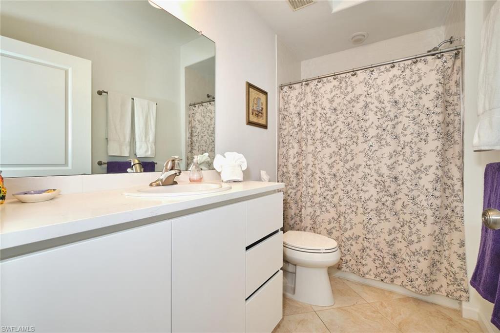 Bathroom featuring vanity, toilet, tile patterned floors, and a shower with shower curtain