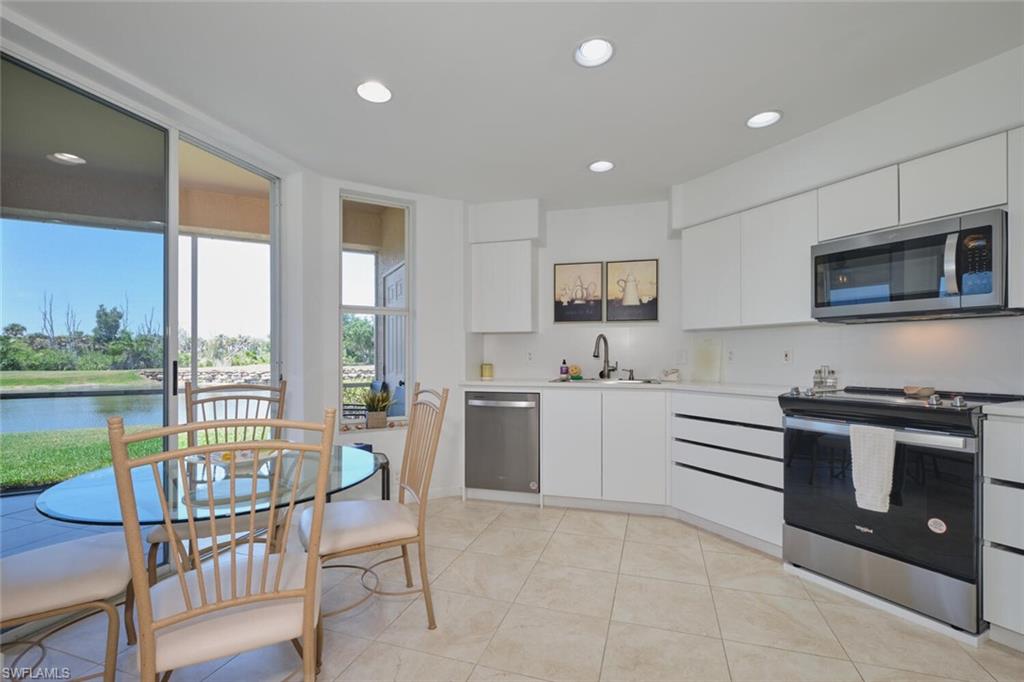 Kitchen with stainless steel appliances, a sink, recessed lighting, light countertops, and white cabinetry