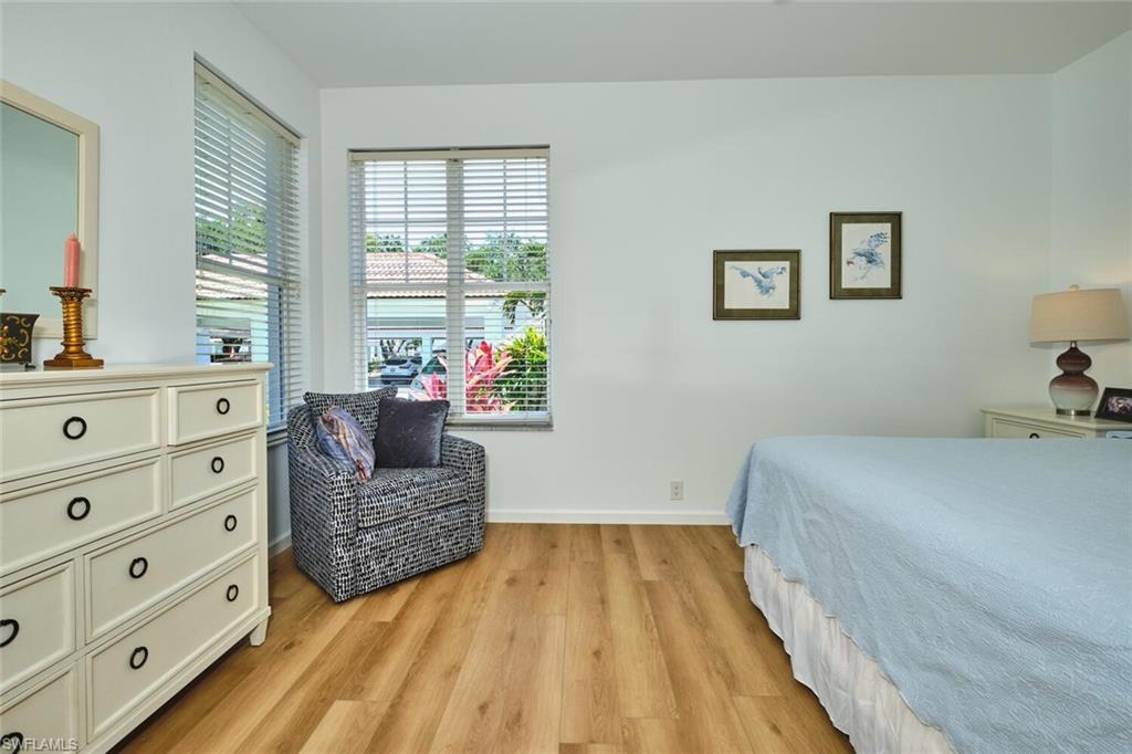 Bedroom with light wood-type flooring, multiple windows, and baseboards