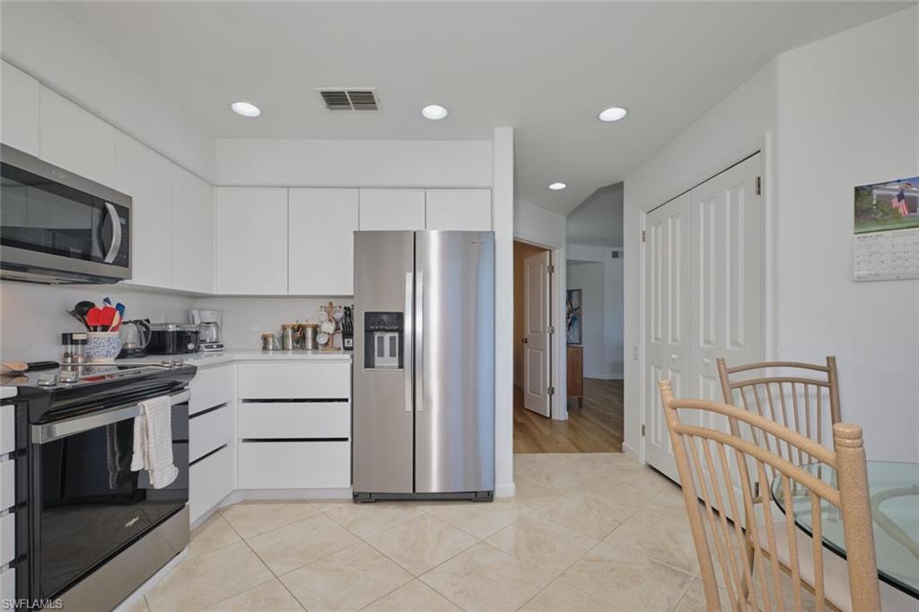 Kitchen featuring stainless steel appliances, white cabinets, light countertops, recessed lighting, and light tile patterned floors
