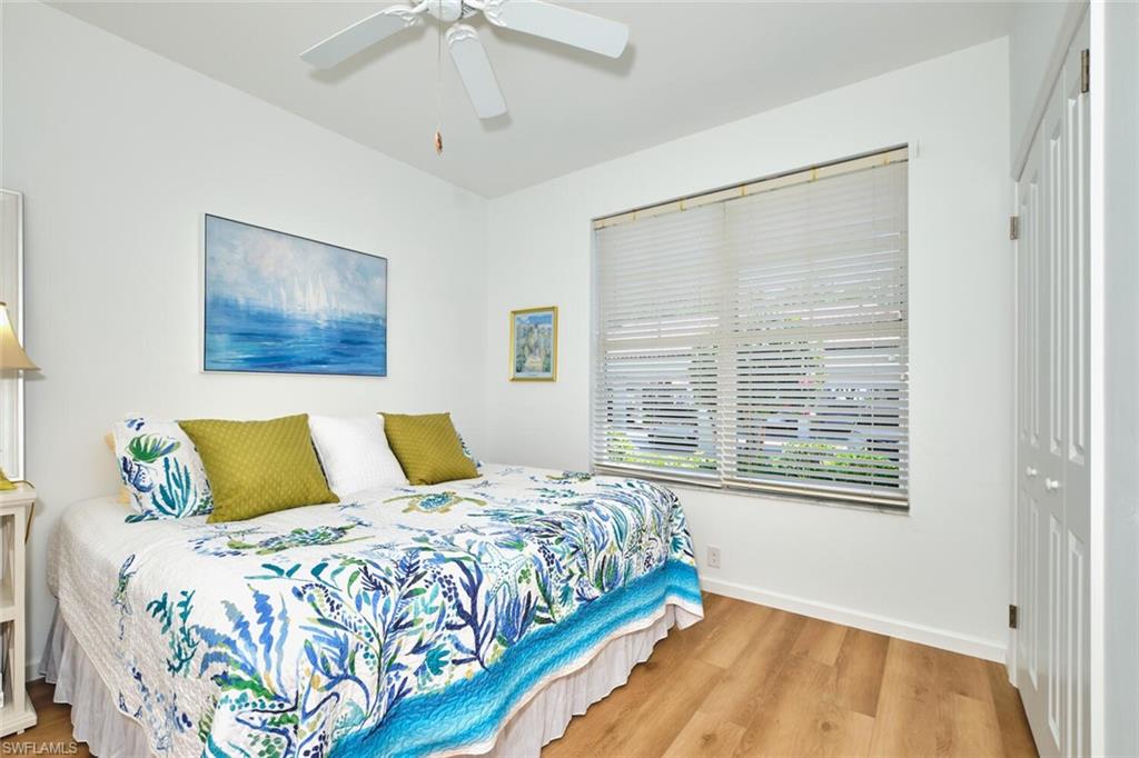 Bedroom featuring wood finished floors, a closet, baseboards, and a ceiling fan