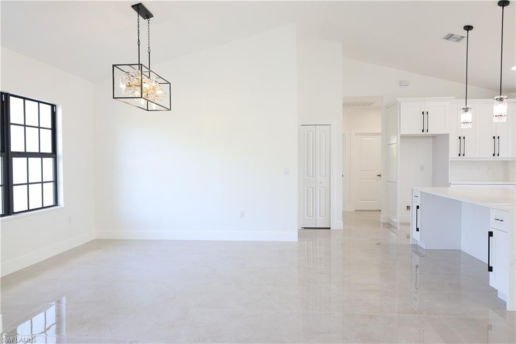 Kitchen with high end appliances, pendant lighting, a kitchen bar, and recessed lighting