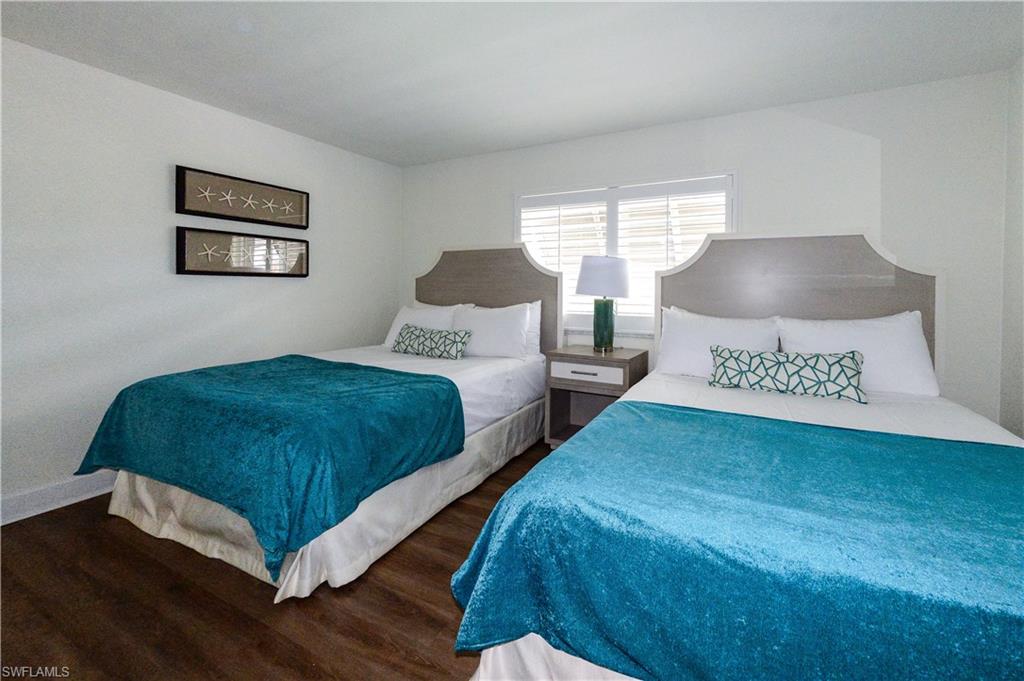 Bedroom featuring dark wood finished floors and baseboards