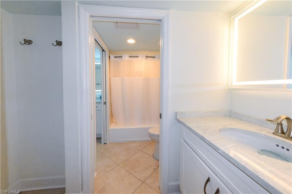Bathroom with vanity, toilet, tile patterned floors, shower / bath combo with shower curtain, and recessed lighting