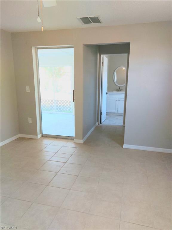 Empty room with baseboards, ceiling fan, and a sink
