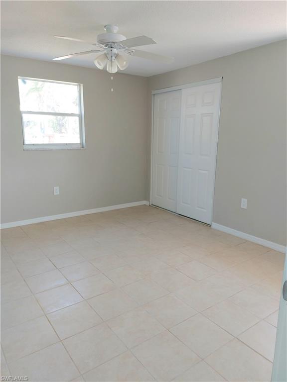 Unfurnished bedroom featuring baseboards, a closet, and a ceiling fan