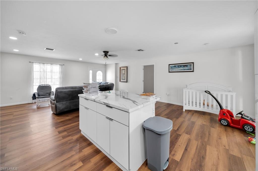 Living area with dark wood-style flooring, recessed lighting, baseboards, and ceiling fan