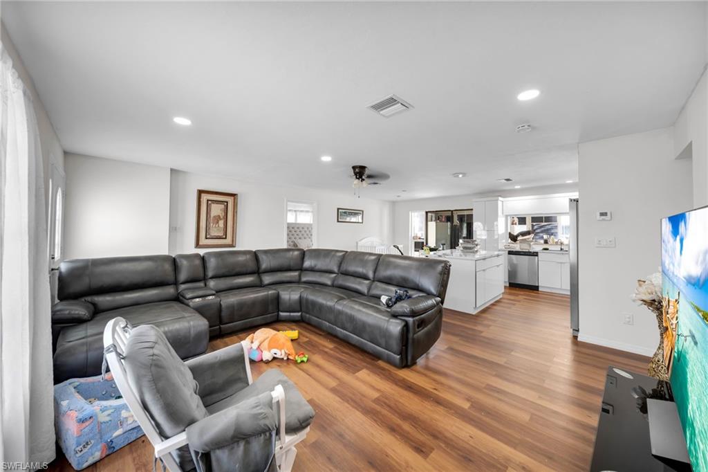 Living area with wood finished floors, recessed lighting, ceiling fan, and baseboards