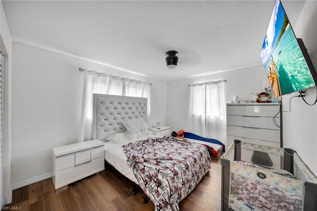 Bedroom with wood finished floors and baseboards