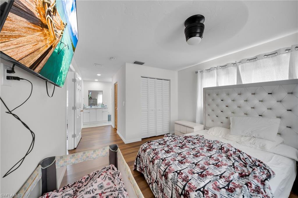 Bedroom with wood finished floors, a closet, and baseboards